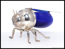 A contemporary honey pot / conserve in the form of a bee being silver plated with blue glass.