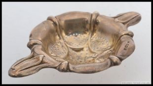 A silver hallmarked tea strainer by Henry Atkin, having a Sheffield Assay mark dated for 1909.  39g.