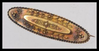 A Victorian 15ct gold ladies oval bar brooch, applied filigree embellishments with gadrooned border.