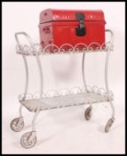 A vintage retro decorative metal worked tea trolley on wheels. Two tier, with glass shelves.