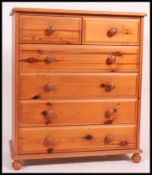 A good quality contemporary pine chest of drawers being raised on a plinth base with an upright