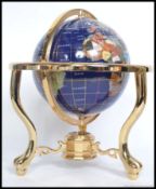 A  20th century gemstone multi stone made globe, on a brass gamble  surround.