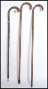 A collection of 3 silver collared walking sticks with crook tops.