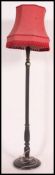 A mid century mahogany standard lamp complete with shade having terraced base with turned stem.