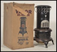 A retro mid century valour oil heater of ebonised cylindrical form complete with the original