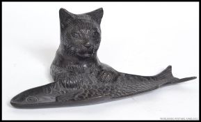 An early - mid 20th century bronze comic dish in the form of a cat resting upon a fish.