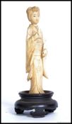 A 19th century antique carved ivory figure of a geisha, mounted on a wooden socle base.