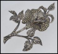 A large silver and marquisite encrusted ladies brooch in the form of a flower with pin to verso.