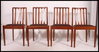 A set of 4 vintage mid century dining chairs being raised on tapered turned legs with bow railed