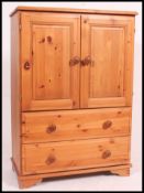 A contemporary country pine tallboy cabinet chest of drawers.