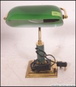 A contemporary vintage style green glass bankers lamp, on a brass metal base.