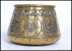An Islamic hand beaten brass, silver and copper inlaid censur pot.