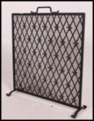 A decorative mid 20th century scratch built wrought iron meshed fire guard
