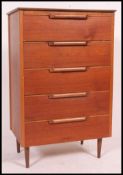 A 1970's retro teak wood chest of drawers. Raised on tapered legs with an upright bank of 5 drawers.