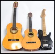 Two acoustic guitars the first being a childs six string along with a three quarter sized six