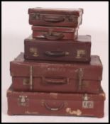 A collection of assorted sized vintage leather travel suitcases, some with monograms to top.