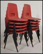 A stack of 10 x 1970's retro orange plastic and tubular metal Industrial dining chairs.