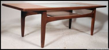 A 1970's retro G-Plan teak wood coffee - occasional table raised on tapered legs with inset glass