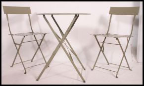 A contemporary painted metal cafe table ( folding )   together with a matching pair of chairs in