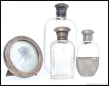 2 silver top and cut glass hallmarked hip flasks together with a small white metal and glass hip