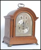 An 20th oak cased mantle clock, having a silvered face with two subsidiary dials,