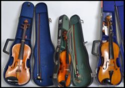 A collection of violins to include student violins,