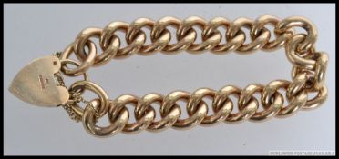 An early 20th century very heavy 9ct gold belcher curb linked bracelet chain complete with heart