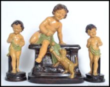 A 1930's plaster fairground prize of young child / cherub sat on a plinth with a playful kitten
