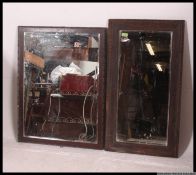 A near pair of Edwardian oak framed mirrors both having central beveled edged mirror panels
