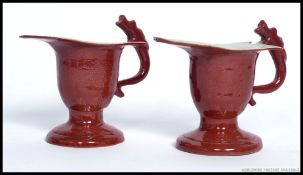 A pair of Chinese monochrome red dragon handled creamers - pourers.
