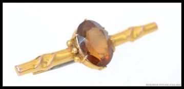 A 9ct gold and topaz set ladies bar brooch with pin to verso, central oval cut stone.