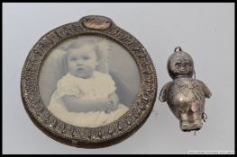 A continental silver metal early 20th century babies rattle along with a small circular silver