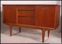 A retro 1970's small proportion teak sideboard raised on tapered legs with sliding door cupboards
