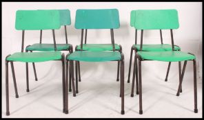 A stack of 1970's retro green plastic and tubular metal Industrial dining chairs.