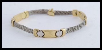 A ladies 14ct white and yellow gold bracelet being white gold mesh linked with yellow gold bars.