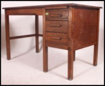 A mid century Air Ministry style oak desk with single pedestal of drawers flanked by open kneehole