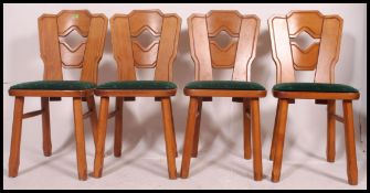 A set of four 20th century retro chairs in the arts and crafts style, having padded seats,