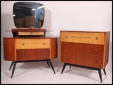 A retro 1950's teak two tone chest of drawers raised on tapered supports with a matching dressing