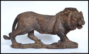 A large hand carved wooden Lion, being constructed from a single piece of wood,