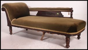 A Victorian mahogany chaise longue raised on turned legs with green velour upholstery,