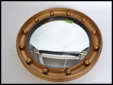 A mid century Regency revival circular convex mirror with ball finial borders,