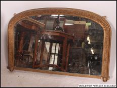 A 19th century  Victorian gilt framed overmantel mirror being raised on bun supports H63cm W95cm