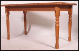A contemporary pine dining table raised on turned legs ( that remove ) with a fitted frieze and