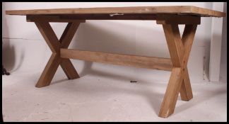 A stunning contemporary chunky country pine refectory dining table raised on an x-frame  trestle