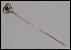 A 14ct gold and amethyst set ladies stick pin. The central stone being claw mounted.