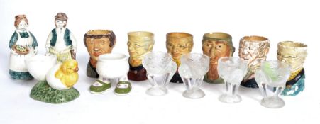 A collection of early to mid 20th century egg cups to include a selection of Charles Dickens