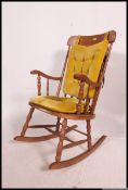 A late 20th century pine spindle back rocking chair on sleigh runners having removable cushions.