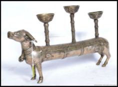 A 20th century white metal Indian elongated cow candlestick holder.