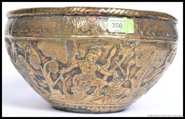A decorative 19th century Indian brass pot being heavily decorated with Hindu mythological figures.