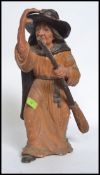 A vintage chalk ware fair ground prize modelled as a witch, with her broom stick.